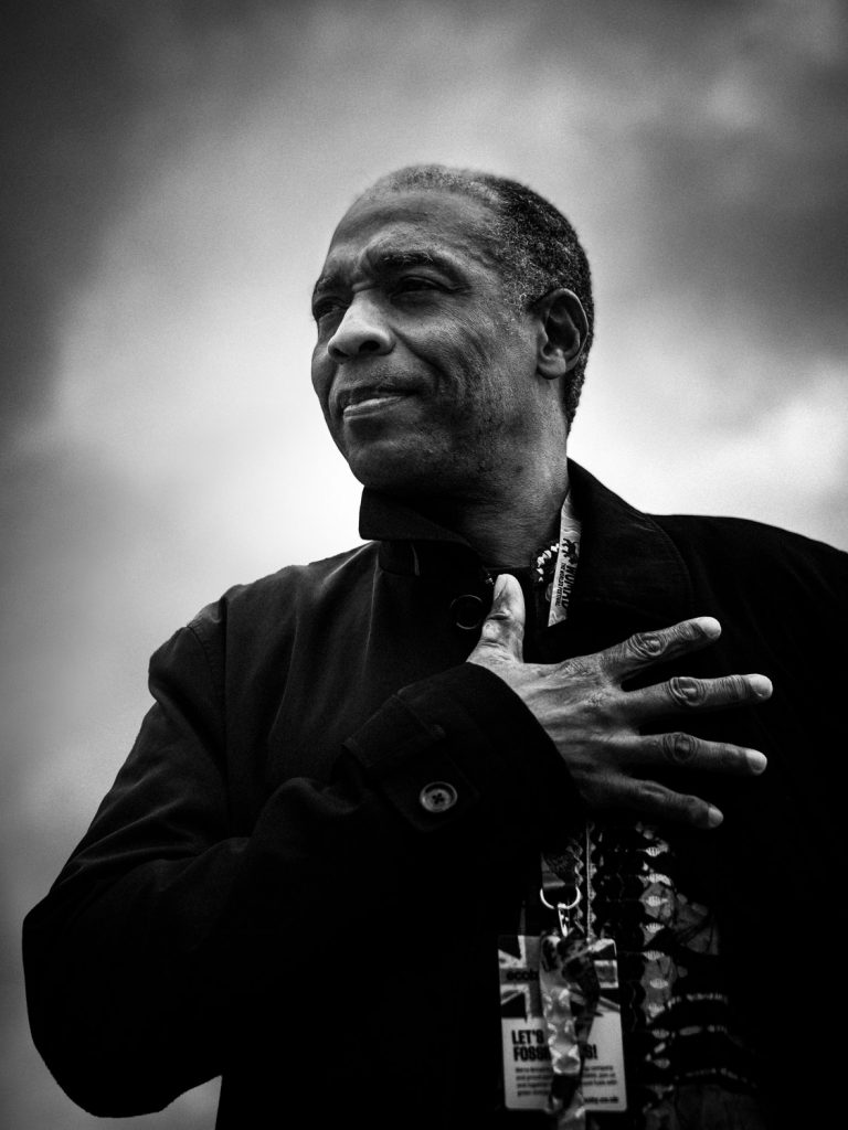 A black and white portrait of Femi Kuti.